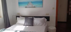 a bedroom with a bed with white sheets and pillows at Apartamento en Avilés Céntrico & Parking in Avilés