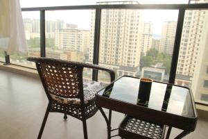 a table and a chair in a room with a window at Miri apartment in Kunming