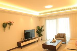 a living room with a flat screen tv and a couch at Miri apartment in Kunming