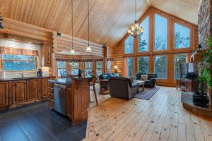 a kitchen and living room in a log cabin at Fiddler Lake Resort - Deer 80 in Mille-Isles
