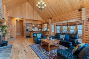 a living room with leather furniture and a wooden ceiling at Fiddler Lake Resort - Deer 80 in Mille-Isles