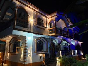 a house lit up at night at Monica guest house in Varca
