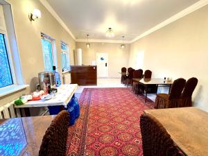 a dining room with tables and chairs and a red carpet at Bukhara house hotel in Bukhara