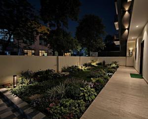 a garden at night with a fence and flowers at BODHI Residency in Greater Noida