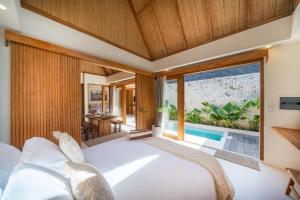 a bedroom with a white bed and a large window at Tropicool Hideaway Villas in Nusa Lembongan +64 photos