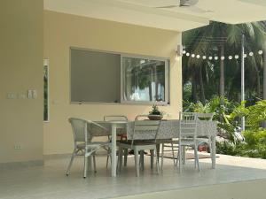 a dining room table and chairs with a television on the wall at Villa Colette in Ban Hua Laem Ma So