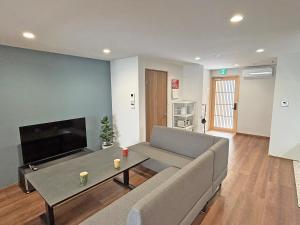 a living room with a couch and a tv at 東寺の宿夏 in Kyoto