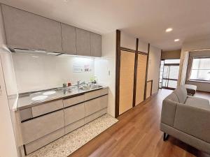 a kitchen with a sink and a couch in a room at 東寺の宿夏 in Kyoto