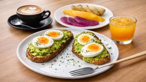 two eggs on toast on a plate with a cup of coffee at Sokchea Kampot Hotel in Kampot