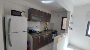 a kitchen with a white refrigerator and a sink at Arena Studio Mar de Ajó in Mar de Ajó +16 photos