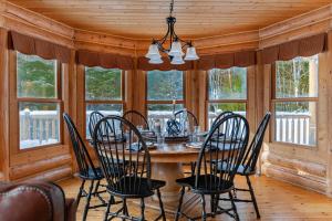a dining room with a table and chairs and windows at Fiddler Lake Resort - Deer 41 in Mille-Isles