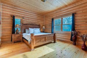 a bedroom with a bed in a log cabin at Fiddler Lake Resort - Deer 41 in Mille-Isles +19 photos