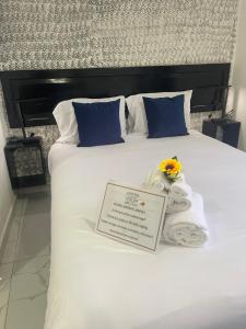 a large white bed with towels and a sign on it at The Bello Lodging B in Sonsonate