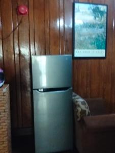 a refrigerator in a kitchen with a picture on the wall at Jenny's transient house in Baguio