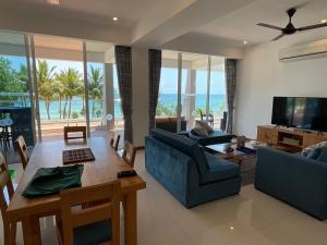 a living room with a couch and a table and a television at Royal Wave, Beachfront, Nilaveli in Trincomalee
