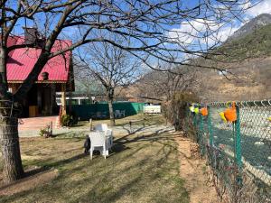 a fence with a white chair in a yard at Birdsong pahalgam in Pahalgām