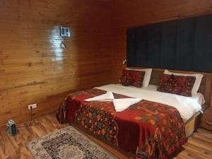 a bedroom with a bed in a wooden room at Birdsong pahalgam in Pahalgām