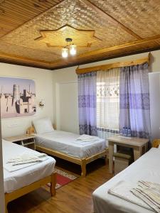 a room with two beds and a window at XIVA AZIM OTA in Khiva