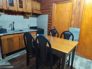 a kitchen with a wooden table and chairs in it at Cabañas Paraje de los Sueños in Uspallata +5 photos