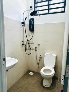a bathroom with a shower and a toilet and a sink at The Luxe Permata by Haffa in Lunas