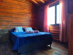 a bedroom with a bed in a wooden cabin at Cabañas Paraje de los Sueños in Uspallata