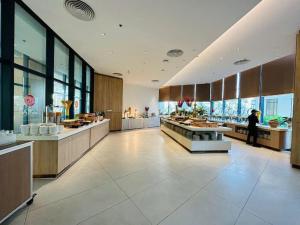 a large kitchen with a person standing in the middle at ARENA JKV condotel in Nha Trang