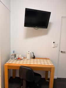 a wooden table with a television on a wall at TJ Homes in Ross Island