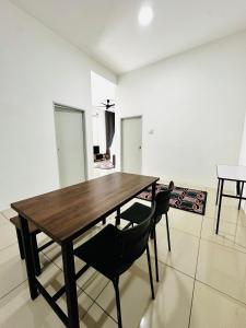 a dining room with a wooden table and two chairs at The Luxe Permata by Haffa in Lunas