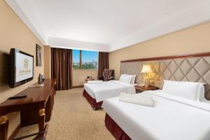 a hotel room with two beds and a desk at 都江堰国堰宾馆 in Dujiangyan