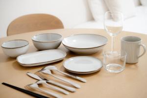 a table with plates and utensils and a wine glass at GuestHouse MIYABI in Kyoto