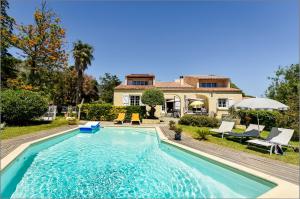 a swimming pool in front of a house at appartement dans villa aquarelle in Biguglia