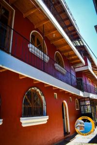 a red building with a balcony on the side of it at Hostal Dulces Sueños in Panajachel