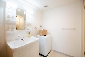 a white bathroom with a sink and a mirror at GuestHouse MIYABI in Kyoto +206 photos