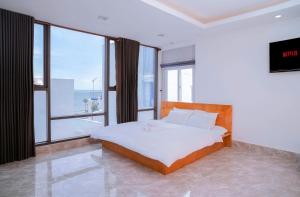 a bedroom with a bed and a large window at The July - Coliving by Kegotel in Vung Tau