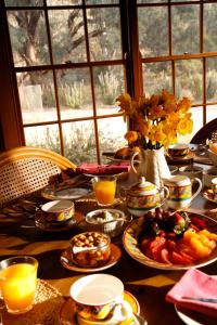 einen Tisch mit Teller mit Speisen und Orangensaft in der Unterkunft Wildwood Guesthouse in Mudgee