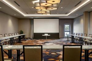 a conference room with tables and chairs and a screen at The Elmore Hotel, DFW Southlake, a Tribute Portfolio Hotel in Southlake +111 photos
