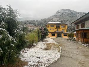 a large yellow building with snow on the ground at Taktshang Paradise in Paro