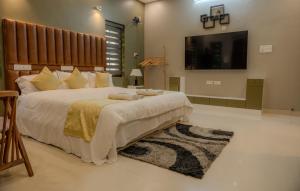 a large bedroom with a large bed and a flat screen tv at Swasth The Riviera Lovedale in Nilambūr