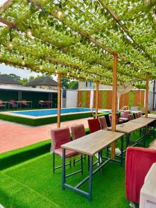 a group of tables and chairs under a pergola at City Xcape Niche in Lekki