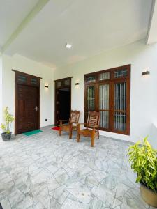 a patio with two chairs and a table at Nithuki Villa Weligama in Weligama