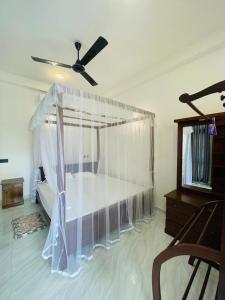 a bedroom with a bed and a ceiling fan at Nithuki Villa Weligama in Weligama