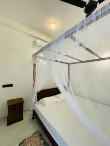 a bedroom with a bunk bed with a mosquito net at Nithuki Villa Weligama in Weligama