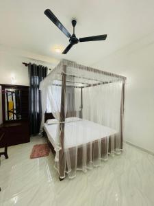 a bedroom with a canopy bed with a ceiling fan at Nithuki Villa Weligama in Weligama