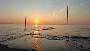 two fishing poles in the water at sunset at 5 Sea Spray in Burnham on Sea