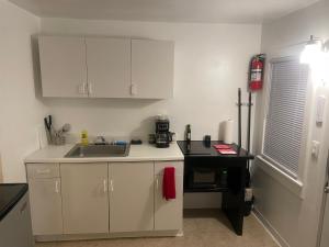 a kitchen with white cabinets and a sink at Tree Star Motel in Monroeton +22 photos