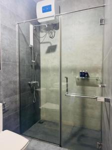 a shower with a glass door in a bathroom at Mack Win Villa in Pannipitiya