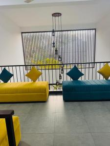 two yellow and blue couches in a room at Mack Win Villa in Pannipitiya +22 photos