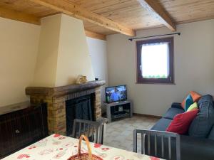 a living room with a couch and a fireplace at GITE*** DES BARAQUES in Fontenoy-le-Château