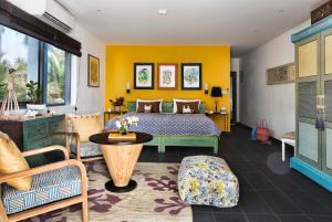 1 dormitorio con 1 cama con pared amarilla en Owl and the Pussycat Hotel & Restaurant, en Unawatuna