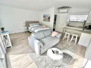 a living room with a couch and a table at Private Barwon Heads Cottage Walk to River in Barwon Heads